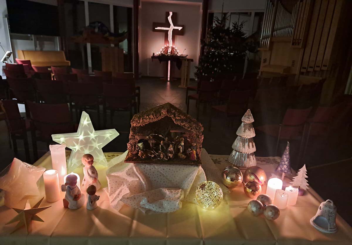 Bild: Lebendiger Adventskalender, Blick in den Kirchenraum auf Adventstisch